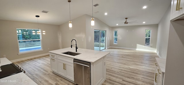 kitchen with white cabinets, open floor plan, a sink, pendant lighting, and stainless steel dishwasher