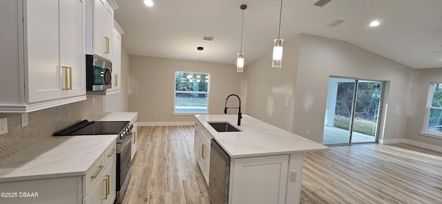 kitchen with stainless steel appliances, a sink, white cabinets, an island with sink, and decorative light fixtures