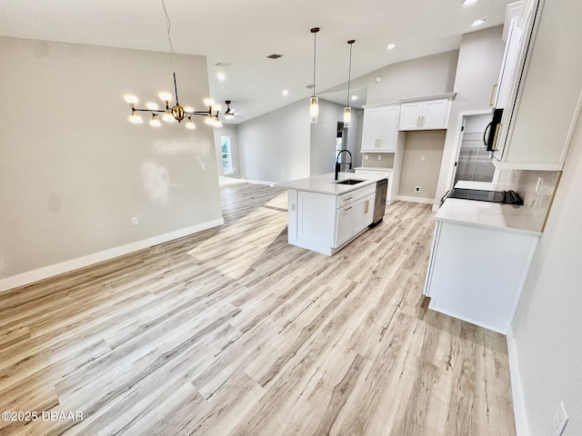 kitchen with dishwasher, an island with sink, light countertops, white cabinetry, and a sink