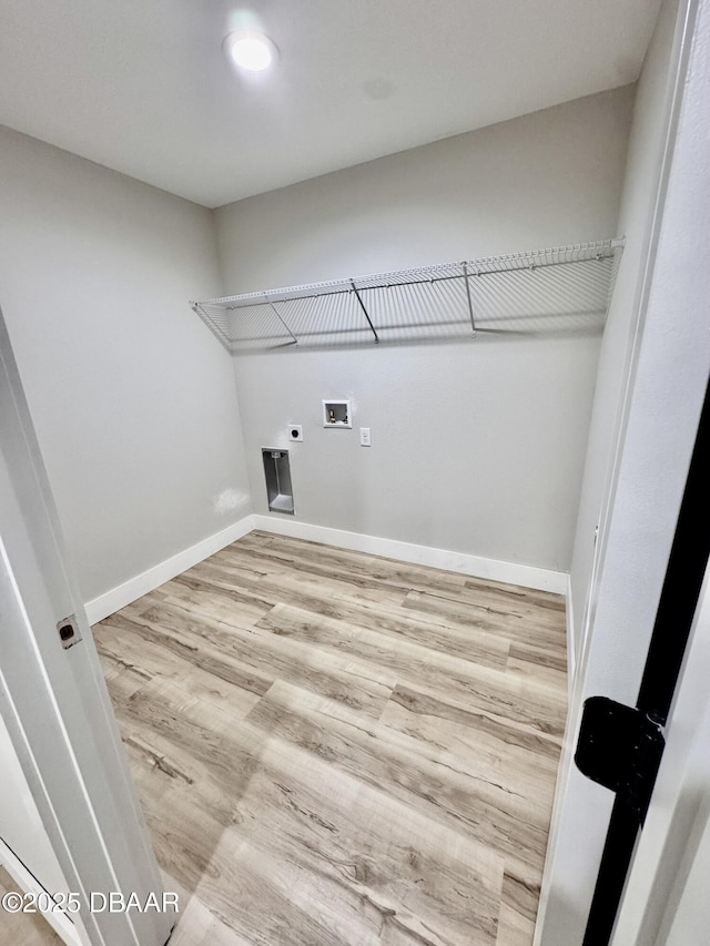 clothes washing area with laundry area, baseboards, wood finished floors, hookup for a washing machine, and electric dryer hookup