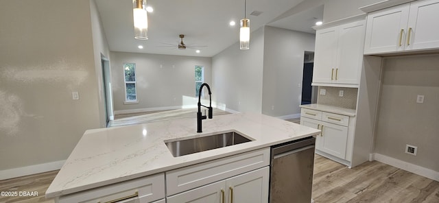 kitchen featuring hanging light fixtures, light stone countertops, white cabinets, and dishwasher