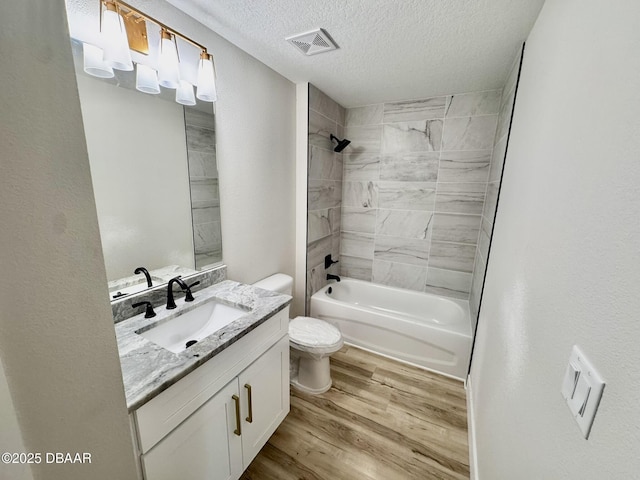 bathroom featuring bathing tub / shower combination, visible vents, toilet, vanity, and wood finished floors