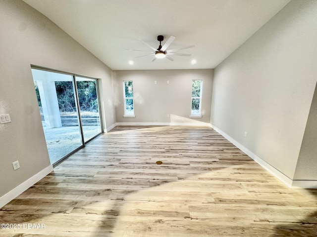 unfurnished room with lofted ceiling, ceiling fan, light wood-type flooring, and baseboards