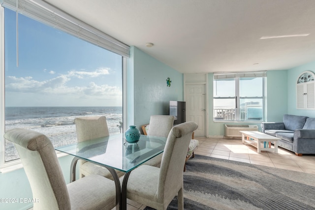 tiled dining area with a view of the beach and an AC wall unit