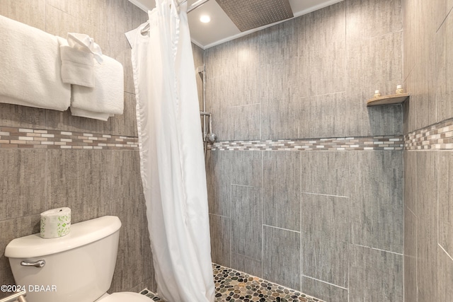 bathroom with tile walls, walk in shower, toilet, and crown molding