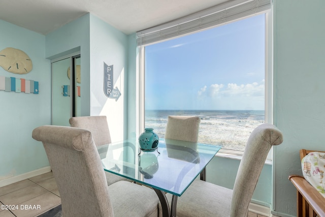 dining room featuring light tile patterned flooring and a water view