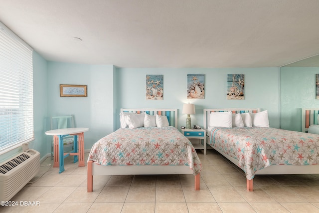 bedroom featuring light tile patterned floors and a wall mounted air conditioner