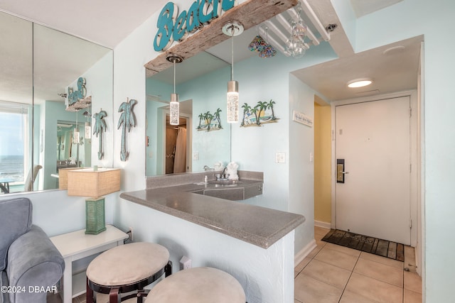 bar featuring pendant lighting, sink, and light tile patterned floors