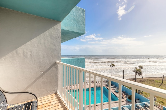 balcony featuring a water view and a beach view