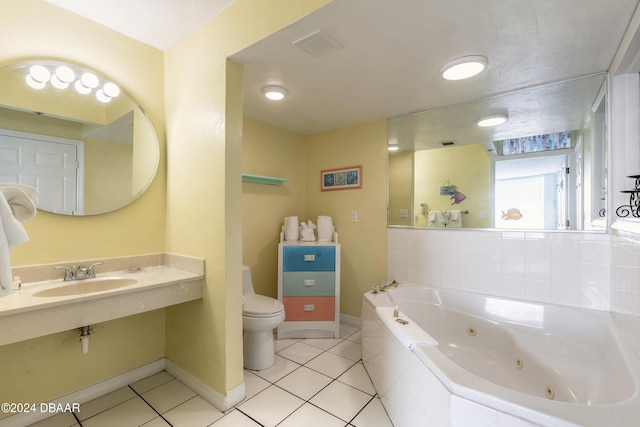 bathroom featuring toilet, sink, tile patterned floors, and tiled tub