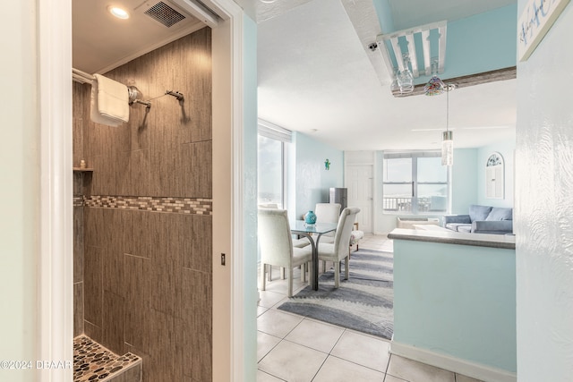 interior space with ornamental molding and light tile patterned flooring