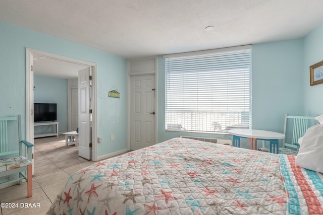 bedroom with light tile patterned flooring and a textured ceiling