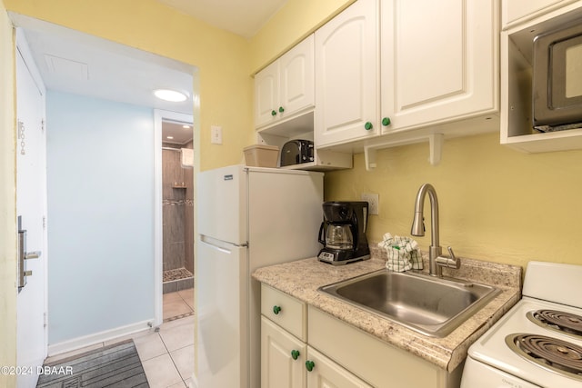 kitchen featuring white cabinets, sink, white appliances, and light tile patterned floors