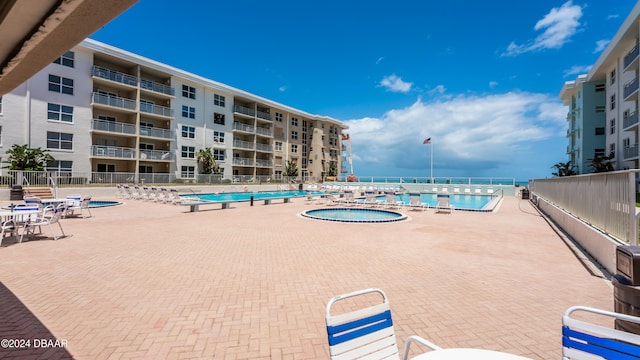 view of swimming pool with a hot tub