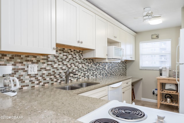 kitchen with sink, light stone countertops, white appliances, white cabinets, and decorative backsplash