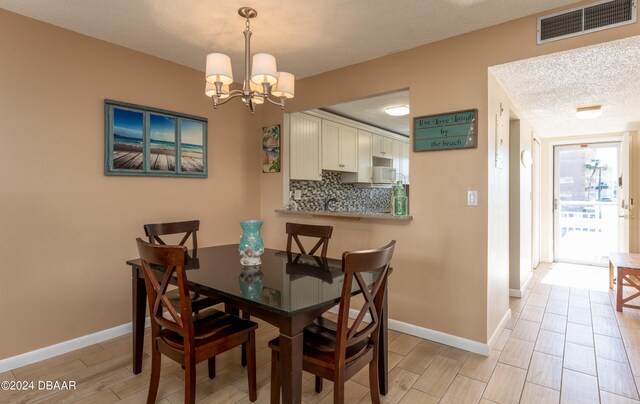 dining room featuring an inviting chandelier and a textured ceiling