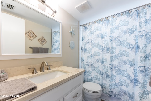 bathroom featuring curtained shower, vanity, and toilet