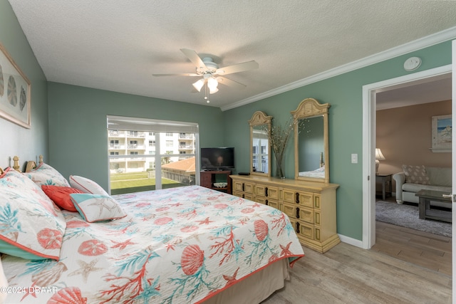 bedroom with a textured ceiling, light hardwood / wood-style flooring, ornamental molding, and ceiling fan