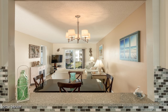 dining space with a textured ceiling and a chandelier