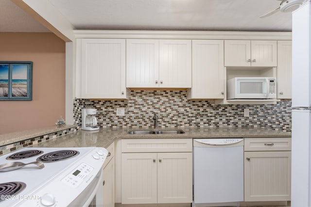 kitchen featuring white cabinetry, sink, white appliances, and backsplash