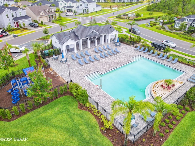 view of swimming pool with a playground, a lawn, and a patio