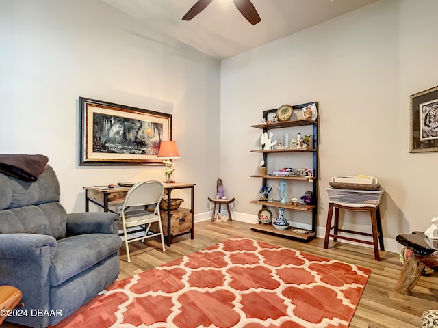 sitting room with hardwood / wood-style floors and ceiling fan