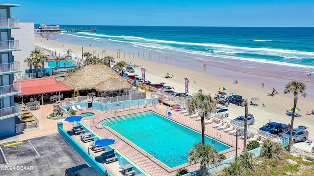 view of pool featuring a view of the beach, a water view, a patio, and a gazebo