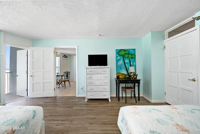 bedroom featuring hardwood / wood-style floors and a textured ceiling