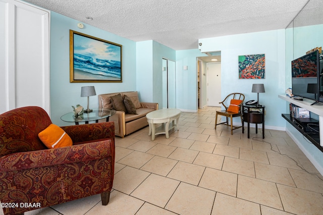 living room featuring a textured ceiling and light tile patterned flooring