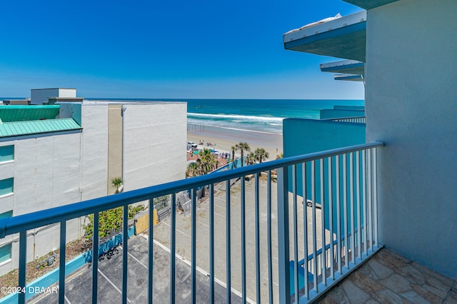 balcony featuring a view of the beach and a water view