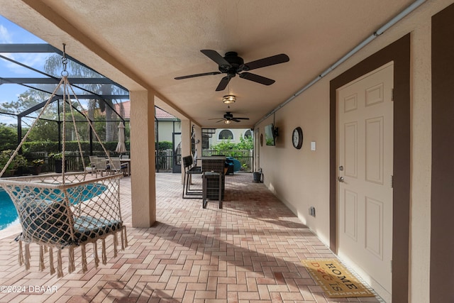 view of patio / terrace featuring glass enclosure and ceiling fan