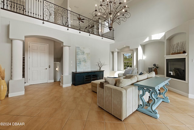 tiled living room featuring a notable chandelier and a towering ceiling