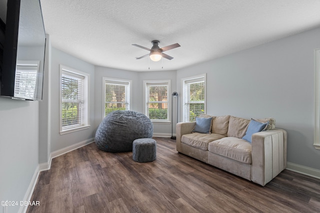 living room featuring dark hardwood / wood-style floors, ceiling fan, a textured ceiling, and a wealth of natural light