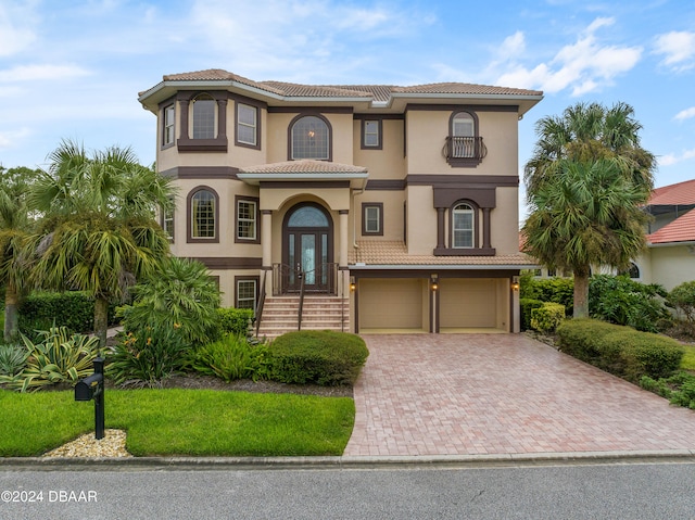 mediterranean / spanish house featuring a garage and french doors