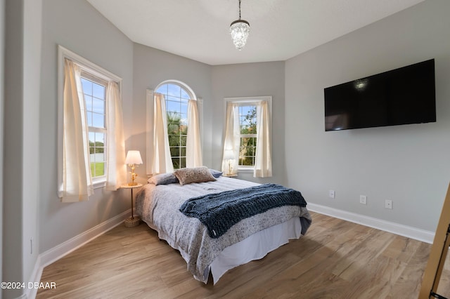 bedroom featuring a chandelier and light hardwood / wood-style flooring