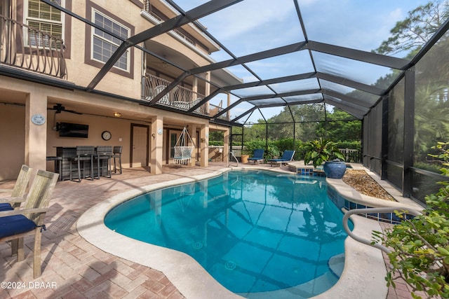 view of swimming pool featuring a lanai, exterior bar, and a patio