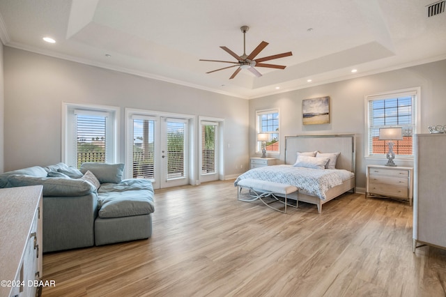 bedroom featuring access to exterior, multiple windows, a raised ceiling, and ceiling fan