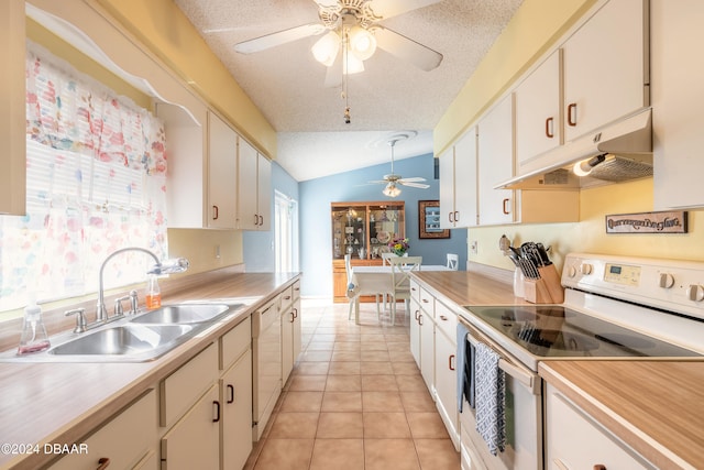 kitchen featuring sink, white appliances, light tile patterned floors, a textured ceiling, and vaulted ceiling