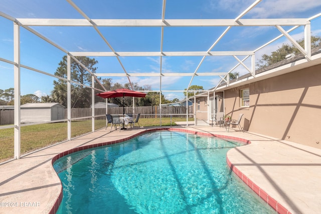 view of pool with a patio, a lanai, a yard, and a storage shed