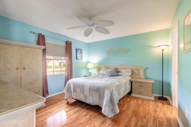 bedroom featuring a textured ceiling, ceiling fan, and light wood-type flooring