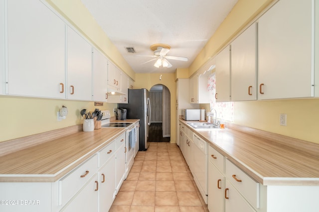 kitchen featuring sink, white appliances, a textured ceiling, ceiling fan, and white cabinets