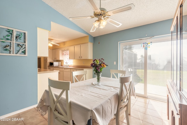 dining area featuring lofted ceiling, a textured ceiling, and light tile patterned flooring