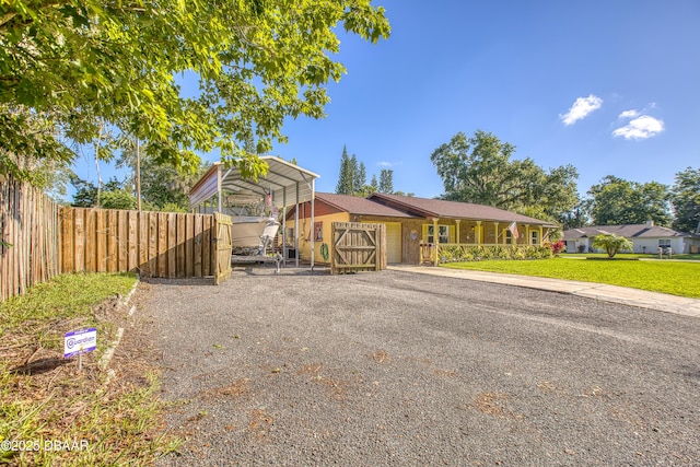 3048 Mango Tree Dr, Edgewater, FL 32141 - view of front of property featuring a detached carport, gravel driveway, and an attached garage
