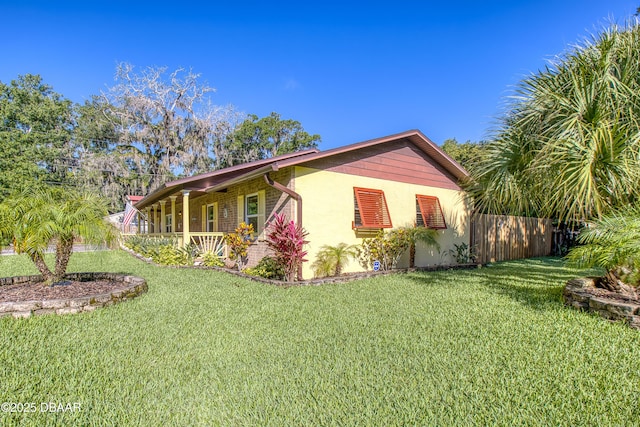 3048 Mango Tree Dr, Edgewater, FL 32141 - view of property exterior featuring covered porch, a yard, and stucco siding