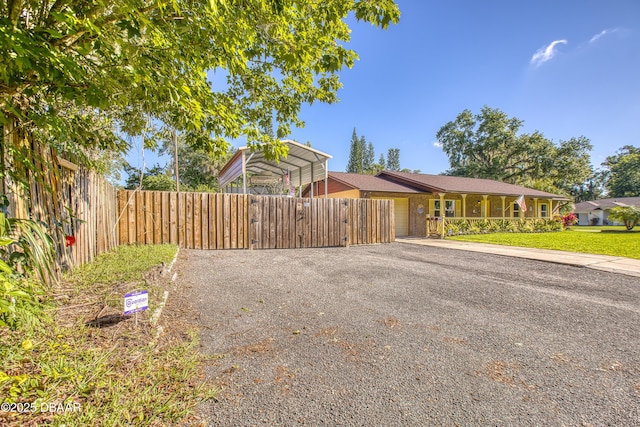 3048 Mango Tree Dr, Edgewater, FL 32141 - view of front of house featuring a carport, driveway, fence, and a garage