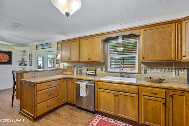 3048 Mango Tree Dr, Edgewater, FL 32141 - kitchen with stainless steel dishwasher, a sink, a peninsula, light countertops, and brown cabinetry