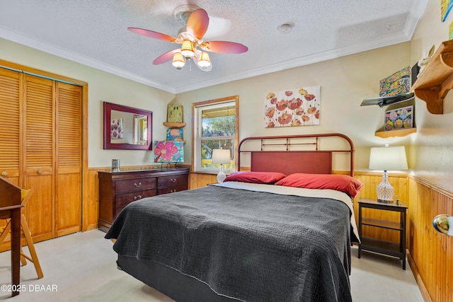 3048 Mango Tree Dr, Edgewater, FL 32141 - bedroom with a wainscoted wall, wood walls, a textured ceiling, a closet, and crown molding