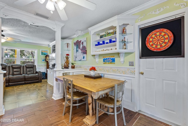 3048 Mango Tree Dr, Edgewater, FL 32141 - dining space featuring ceiling fan, a textured ceiling, wainscoting, ornamental molding, and light wood-style floors