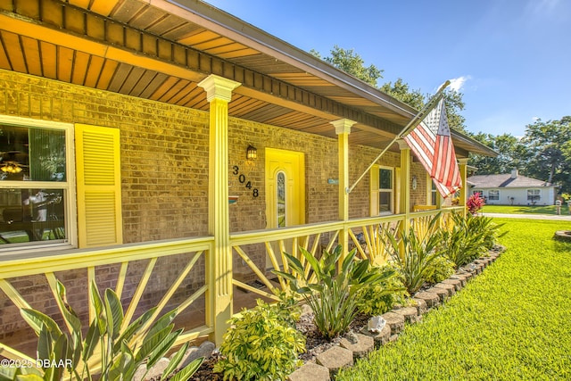 3048 Mango Tree Dr, Edgewater, FL 32141 - view of property exterior featuring brick siding, a yard, and covered porch