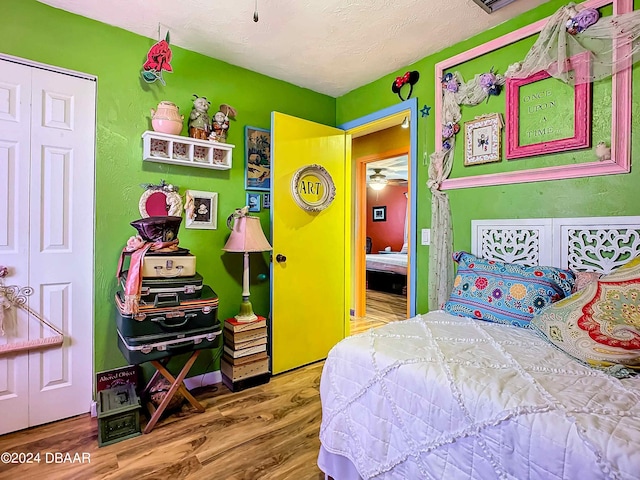 bedroom featuring hardwood / wood-style flooring, a textured ceiling, and a closet